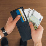Bovenaanzicht van zakenman die geld uit portomonnee haalt