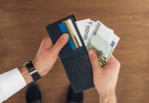 Bovenaanzicht van zakenman die geld uit portomonnee haalt