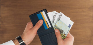 Bovenaanzicht van zakenman die geld uit portomonnee haalt