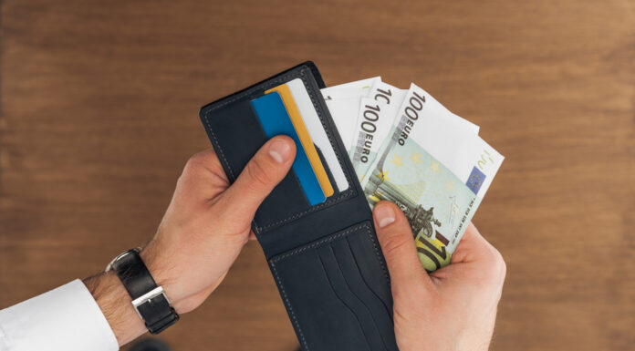 Bovenaanzicht van zakenman die geld uit portomonnee haalt